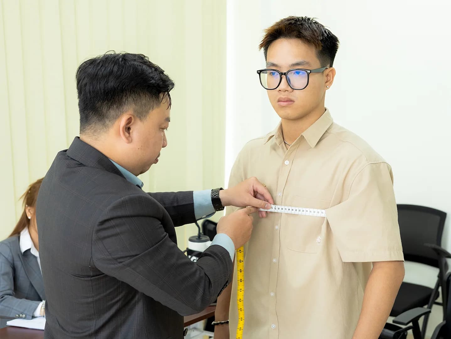 Đo ngang ngực cho nhân viên trẻ, thước dây rõ nét