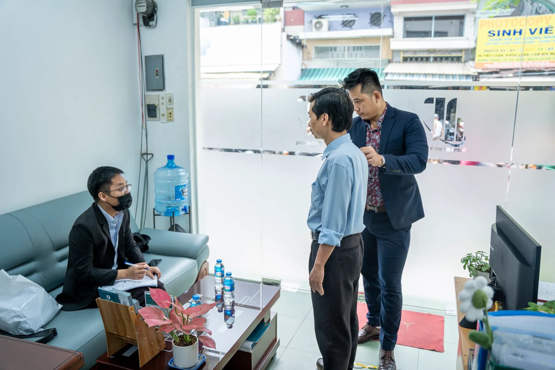 Đo vai cho nhân viên nam tại sảnh Viện, có người ghi chép
