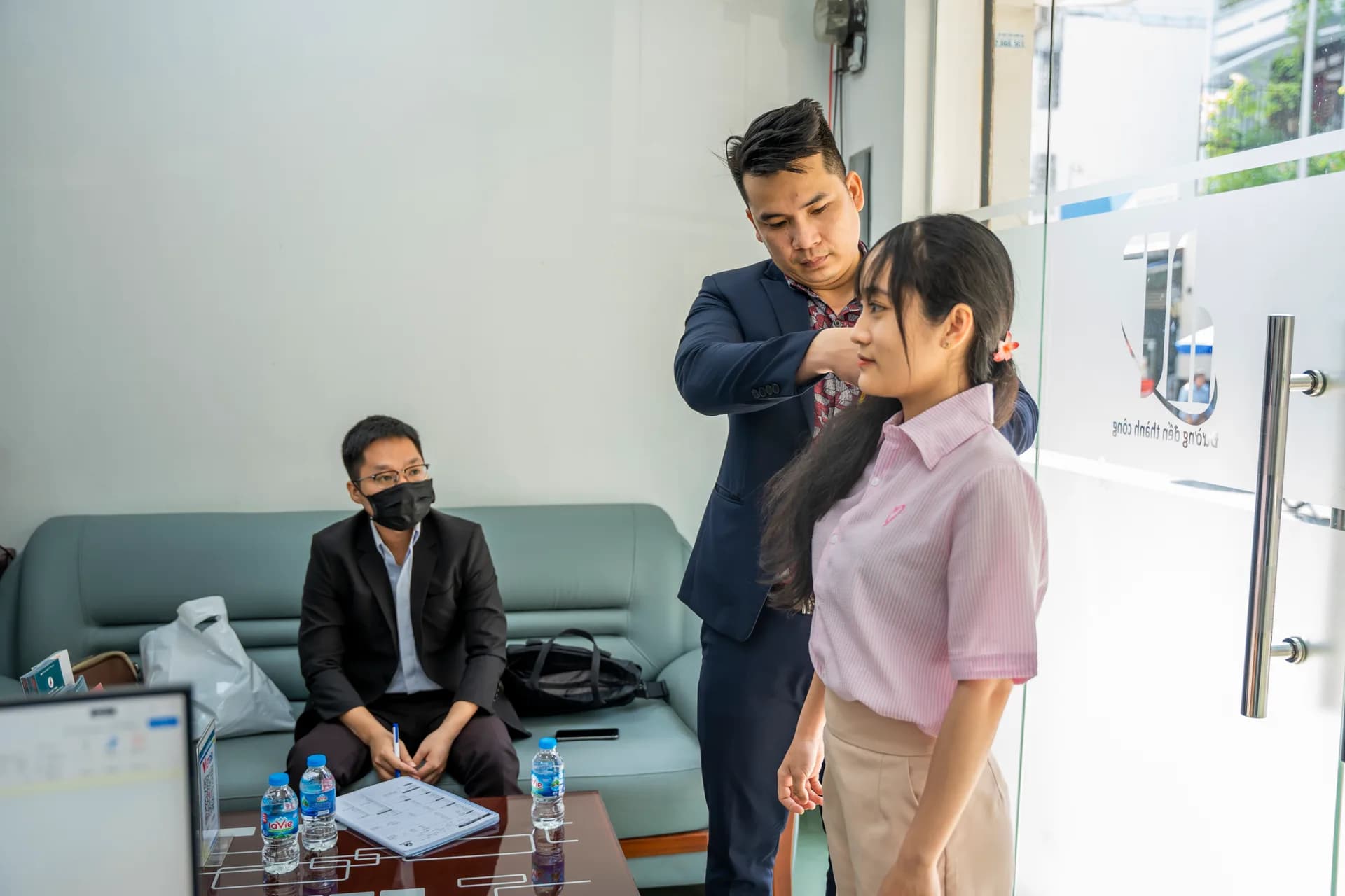 Đo vòng cổ cho nhân viên nữ mặc áo sơ mi hồng