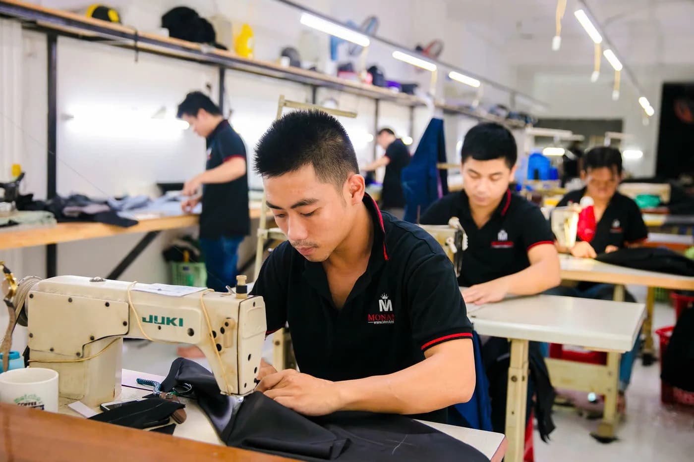 Dãy thợ áo polo đen đồng phục may vest trên máy Juki