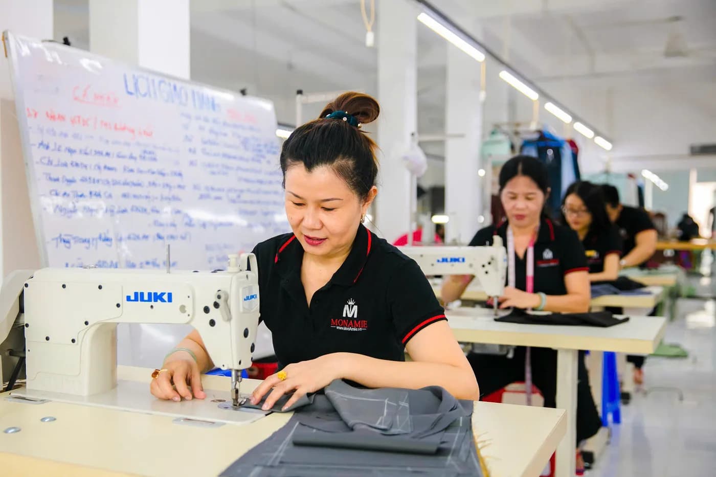 Tổ nữ thợ áo polo đen đồng phục may vest xám trong xưởng
