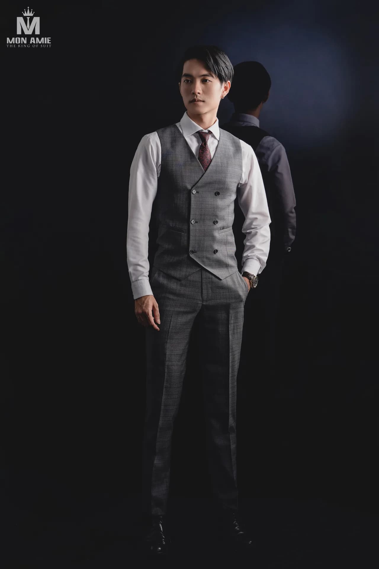 Suit kẻ ô xanh xám, gilet đỏ rượu và cà vạt sọc bên bàn phụ kiện