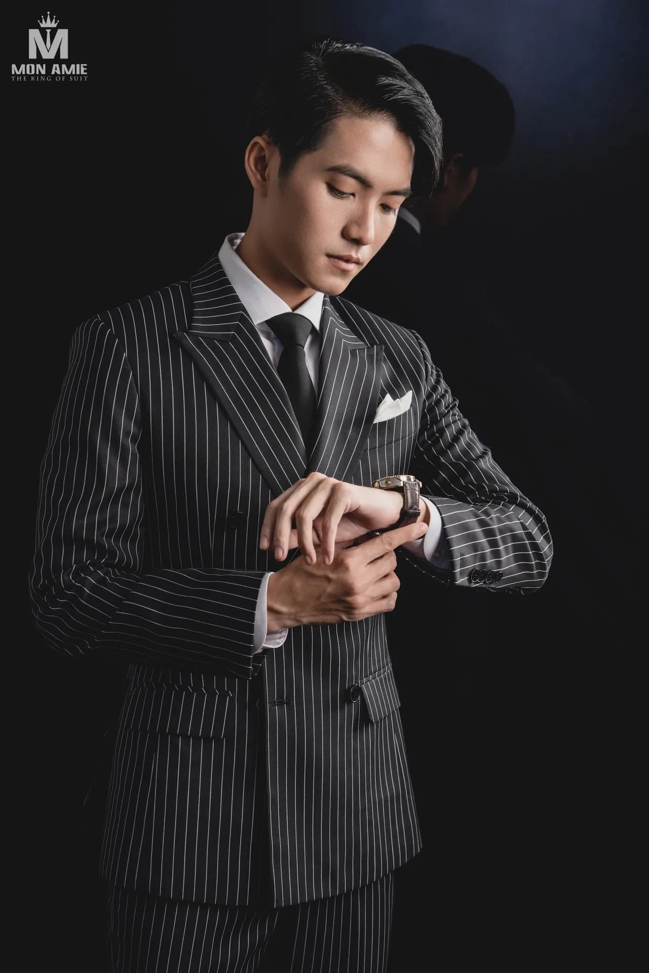 Vest kẻ sọc đen trắng hai hàng khuy, cà vạt đen, xem đồng hồ
