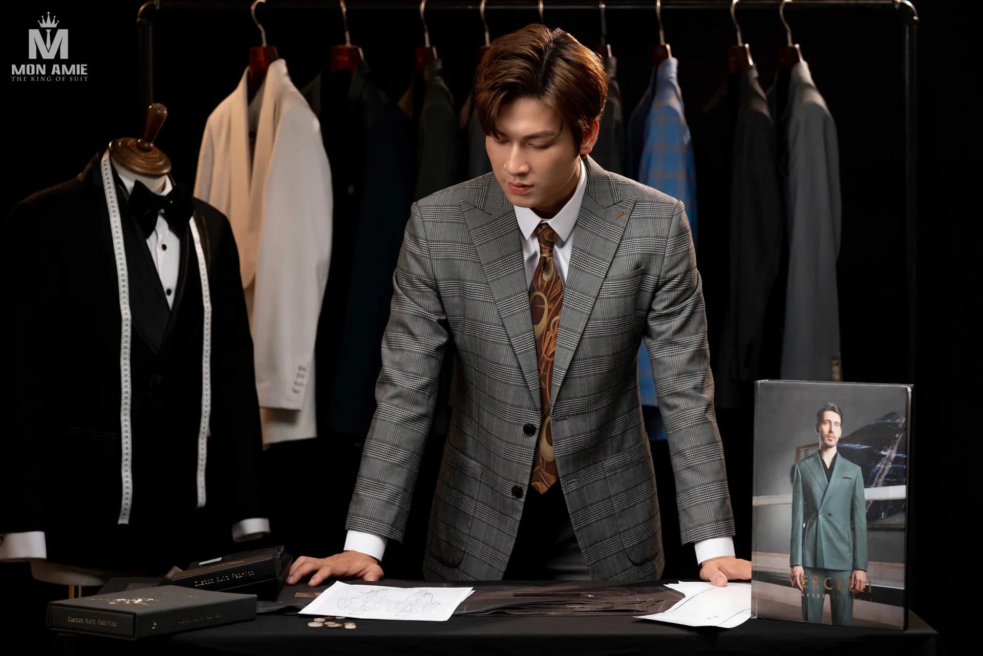 Toàn cảnh bàn cắt may, mannequin tuxedo và giá treo suit phía sau