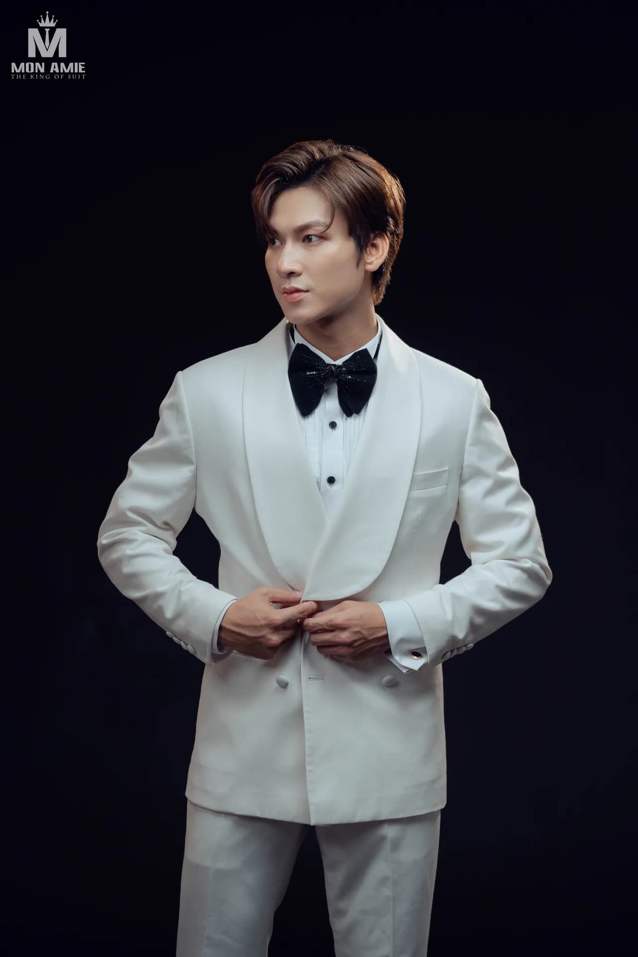 Tuxedo trắng cổ ve shawl, nơ đen nổi bật trên nền tối