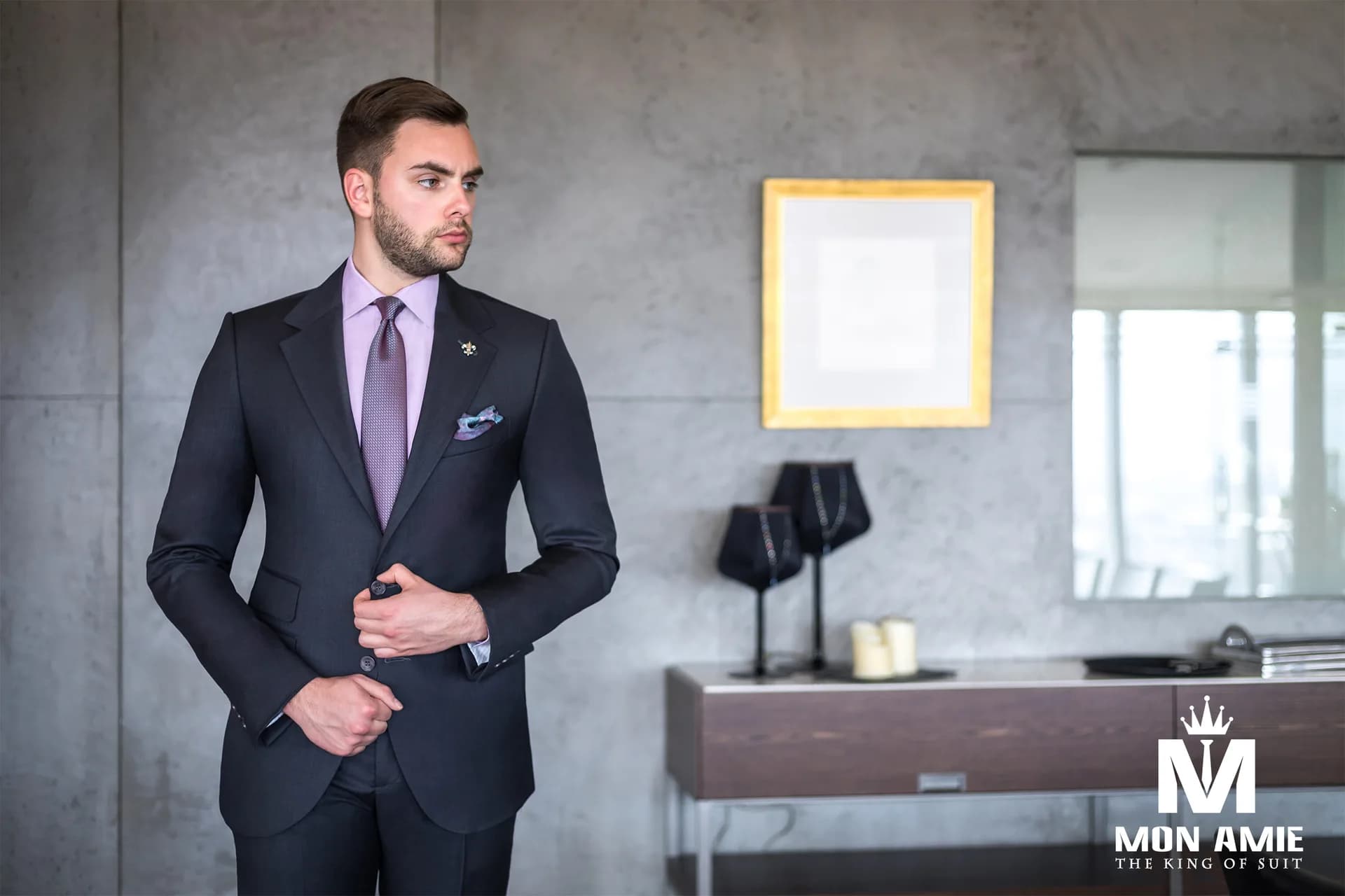 Suit xanh than tối giản, sơ mi tím nhạt phối cà vạt, tường bê tông