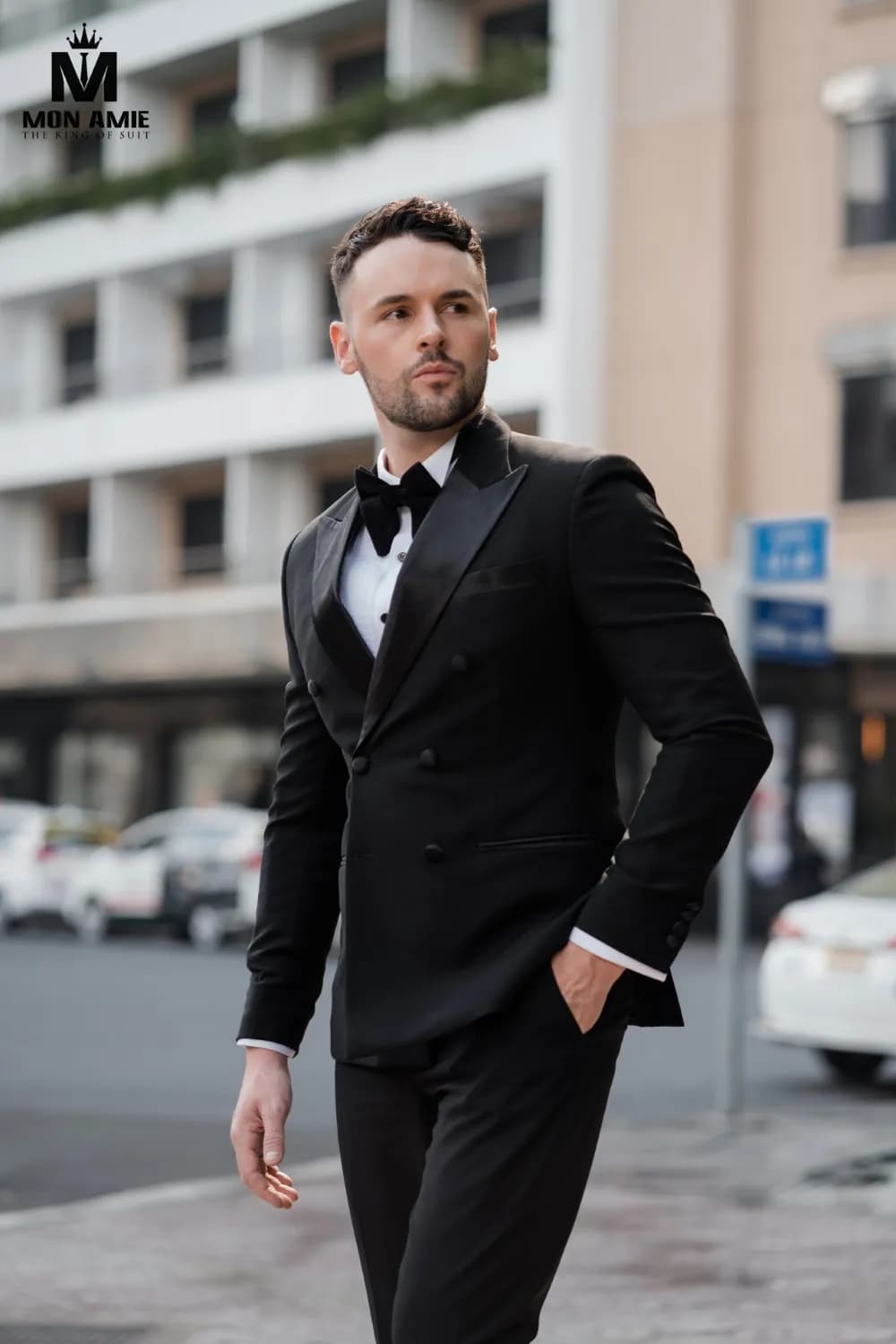 Tuxedo đen nơ nhung, bước đi giữa phố, tay đút túi quần