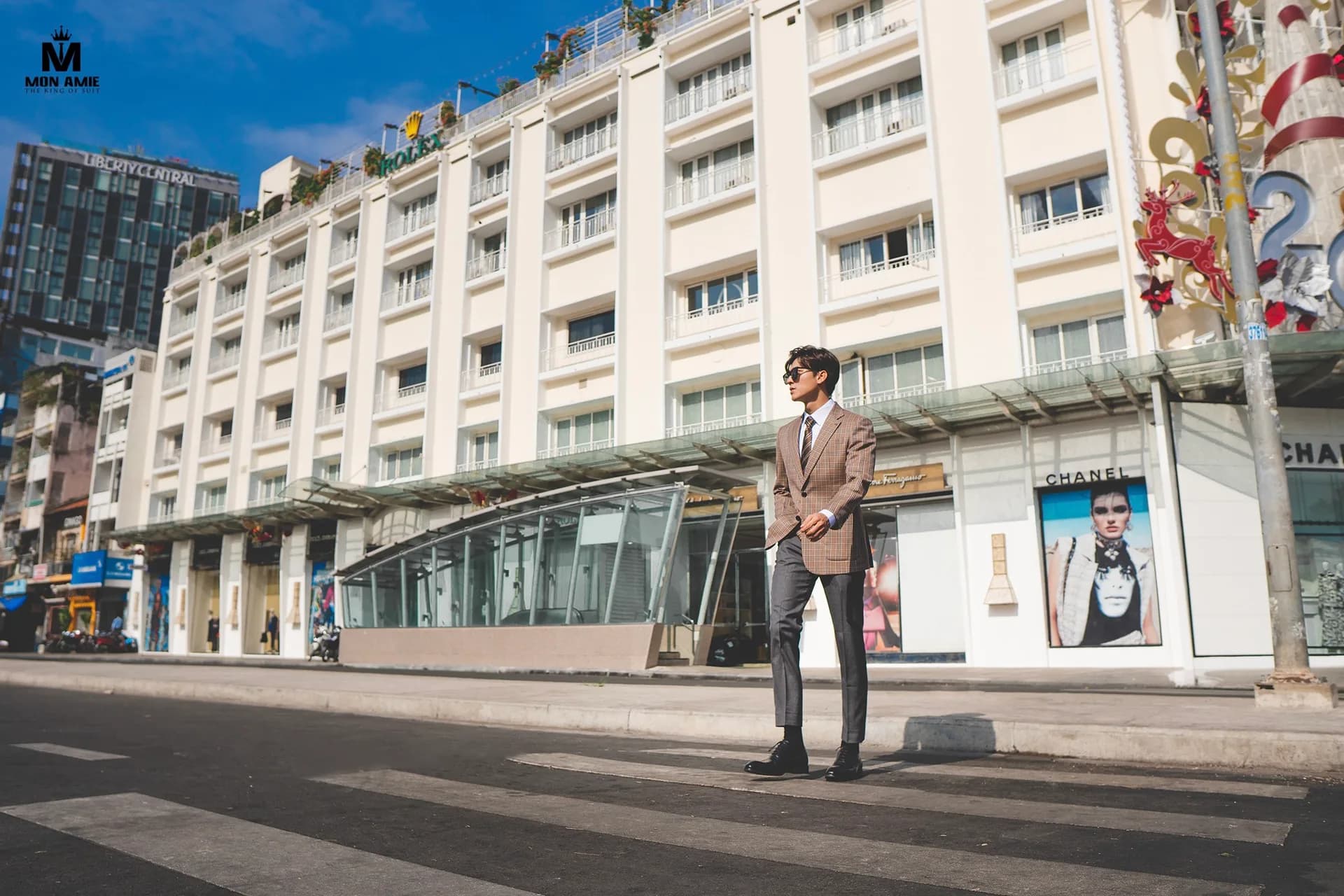 Bộ suit ghi xám, nơ cổ và ghế gỗ cổ điển trong studio