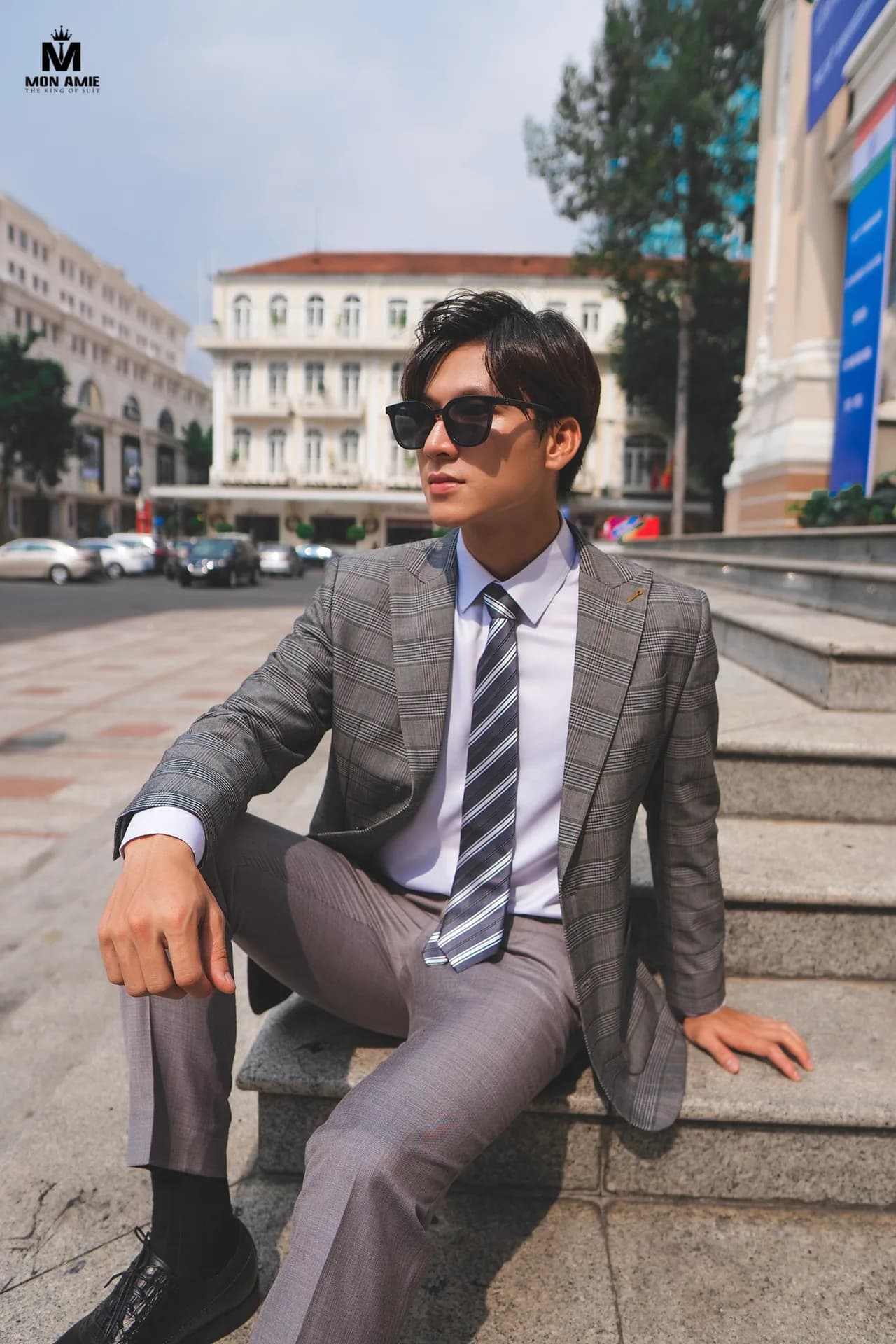 Tuxedo đen ba mảnh, ngồi sofa da chesterfield giữa phòng tường phào