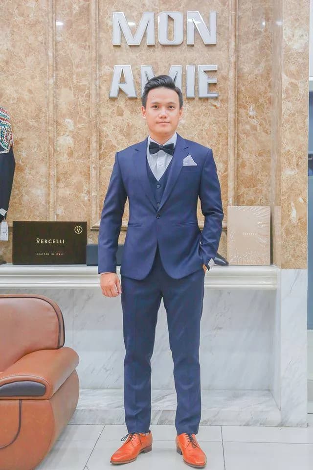 Suit ba mảnh xanh navy nơ đen, khăn cài túi trắng, giày da bò nổi bật