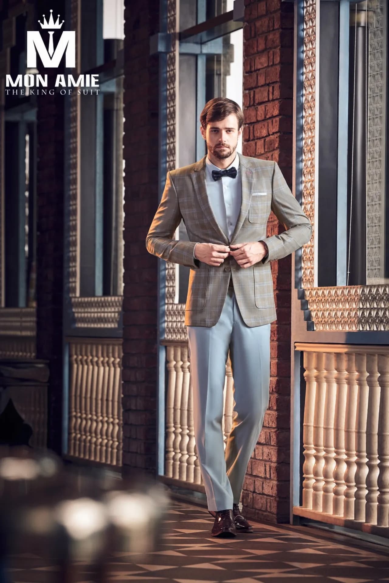 Blazer ca-rô nâu be, quần xanh nhạt, nơ xanh, bên hành lang cổ điển