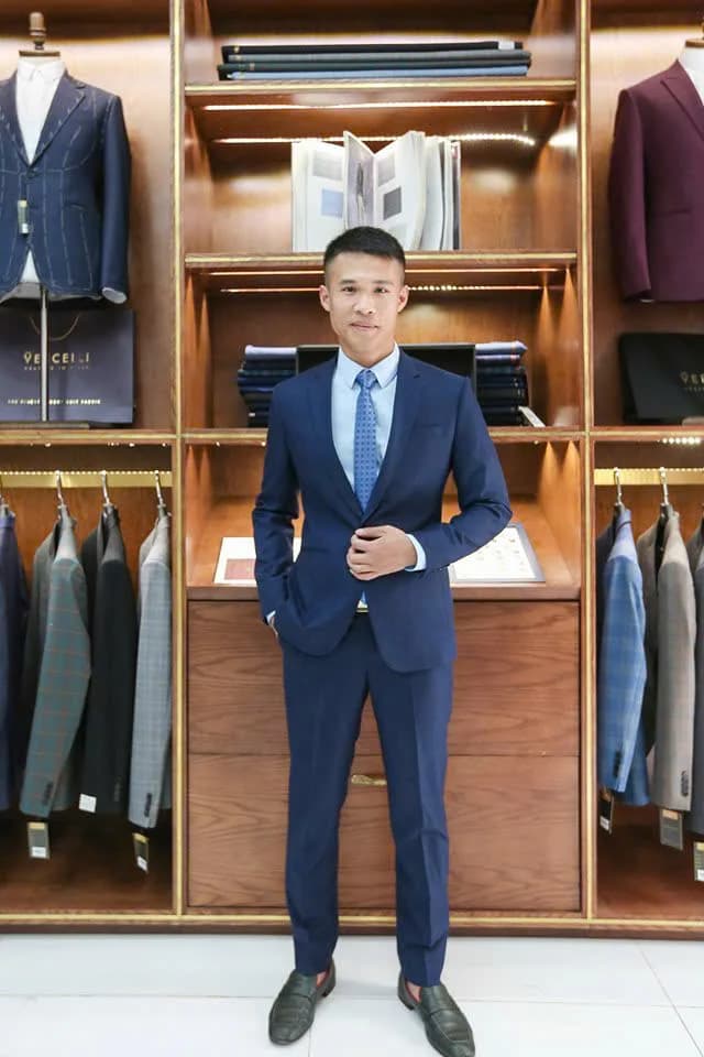 Chàng trai vest navy, cà vạt xanh chấm bi, showroom gỗ