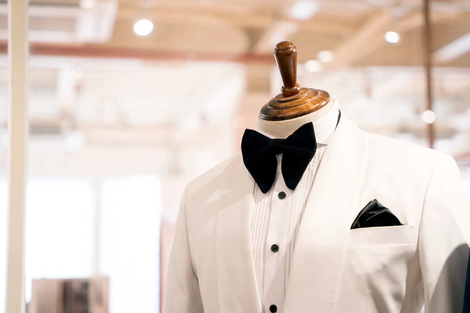Tuxedo trắng cổ lụa, nơ nhung đen và khăn cài túi trên manơcanh