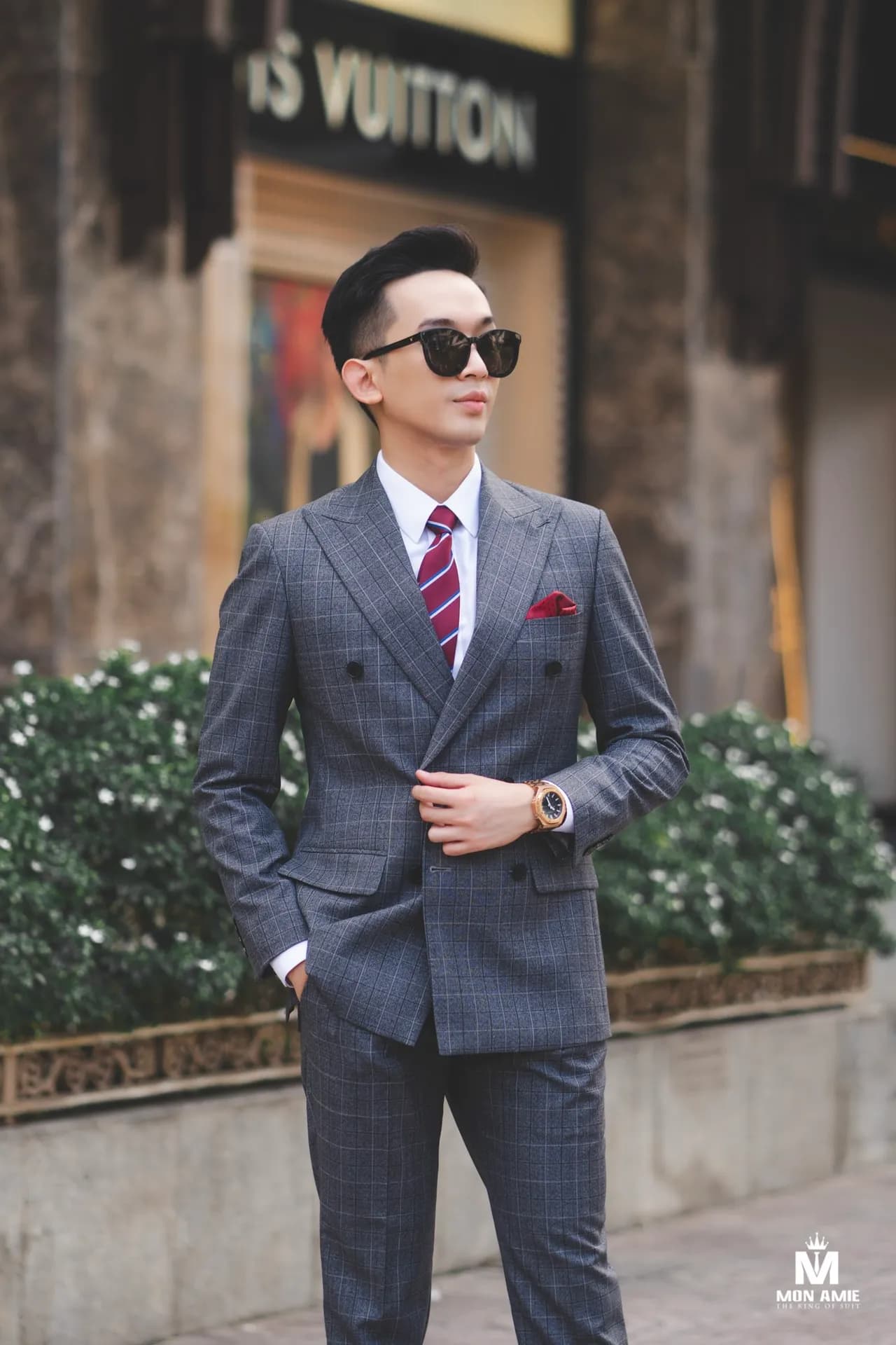 Suit xám caro hai hàng khuy, cà vạt sọc đỏ, kính râm, dạo phố