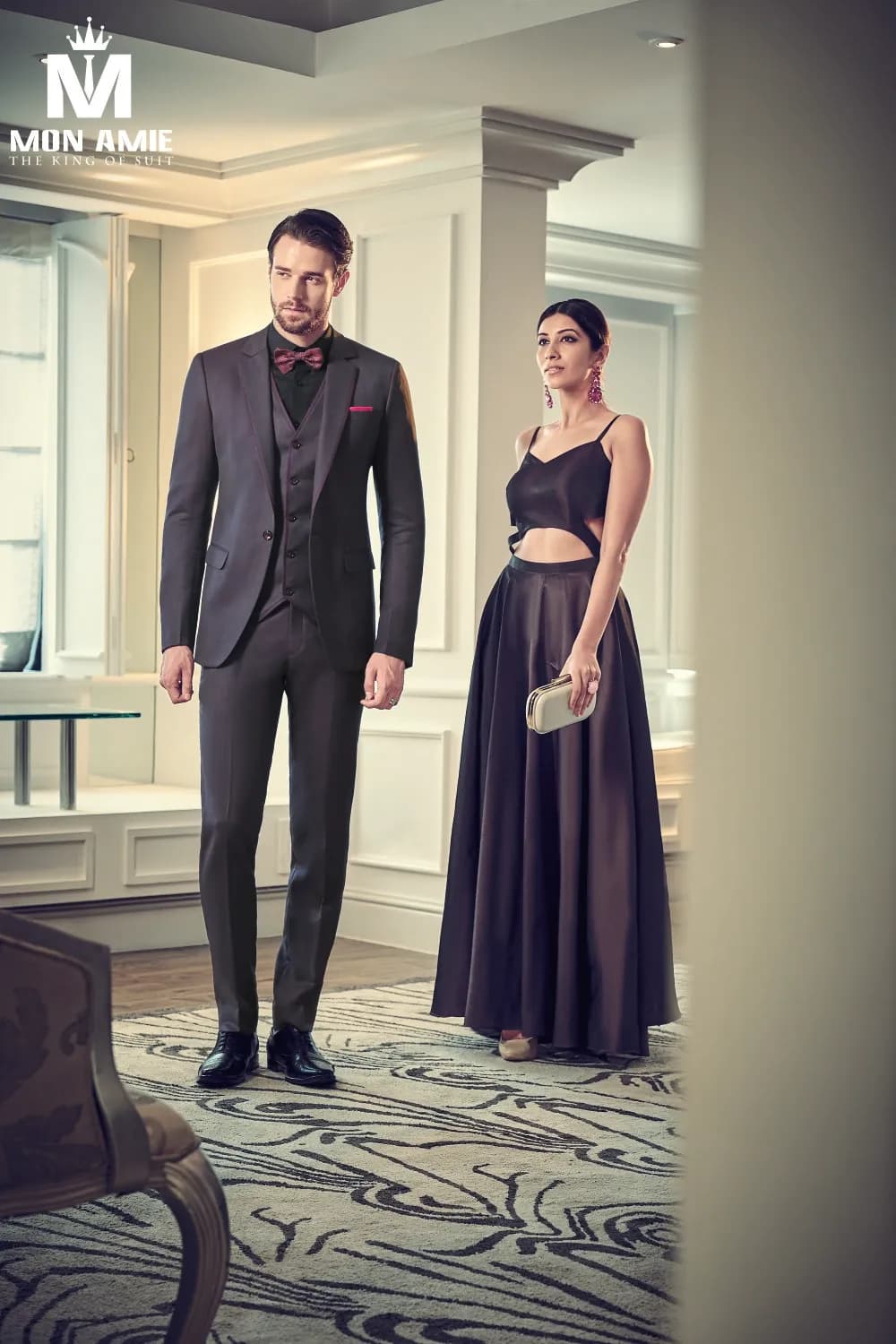 Suit xám than ba mảnh nơ tím, sánh đôi cùng váy dạ hội, sảnh sang trọng
