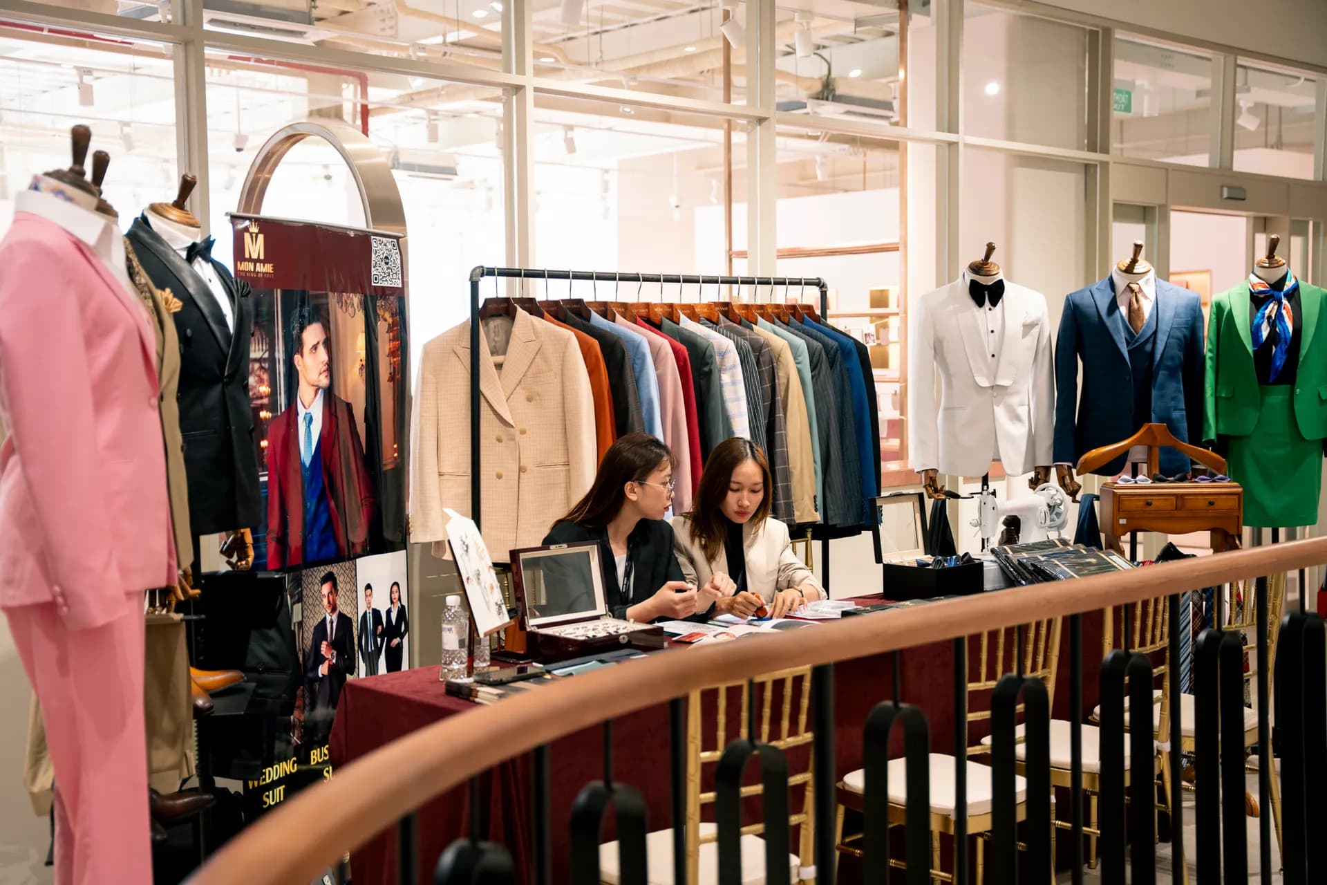 Gian trưng bày vest: manơcanh hồng, be, tuxedo trắng và giá treo áo nhiều màu
