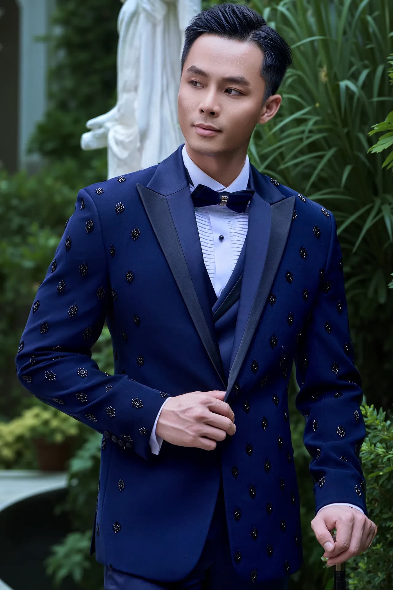Tuxedo xanh navy ve đen cận cảnh, nơ đen, nền cây xanh