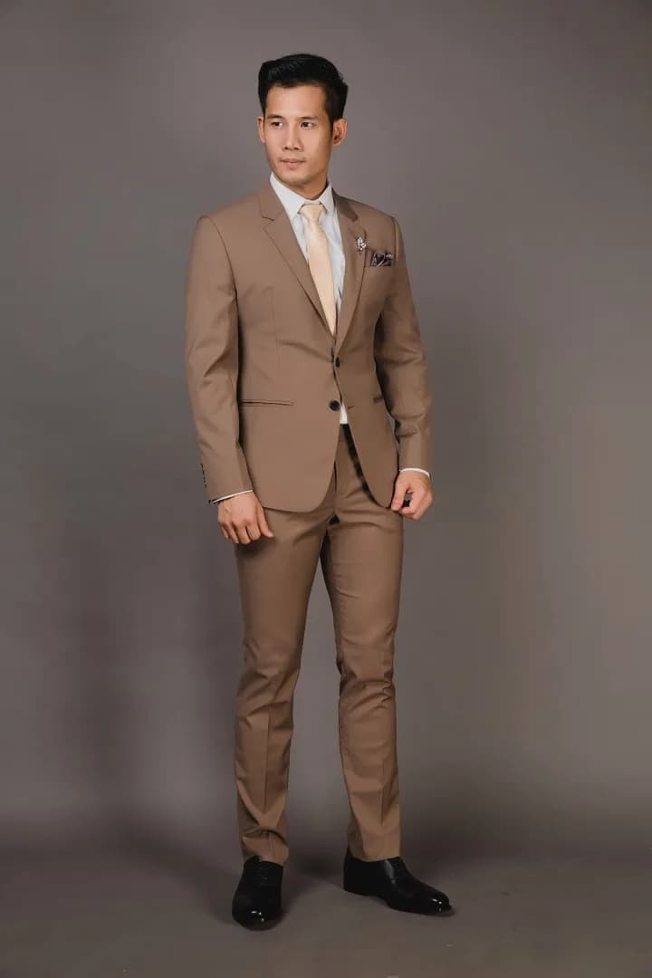Blazer nhung đỏ mặc với sơ mi đen, tựa tủ gỗ sồi