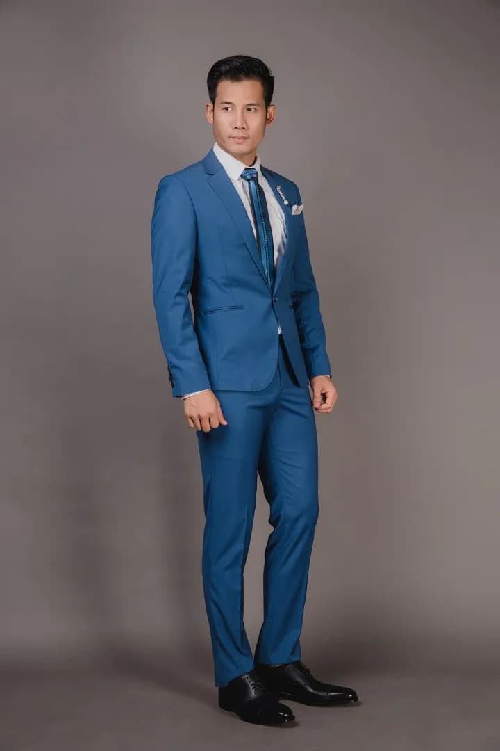 Suit xanh dương một hàng khuy, cà vạt xanh, dáng đứng