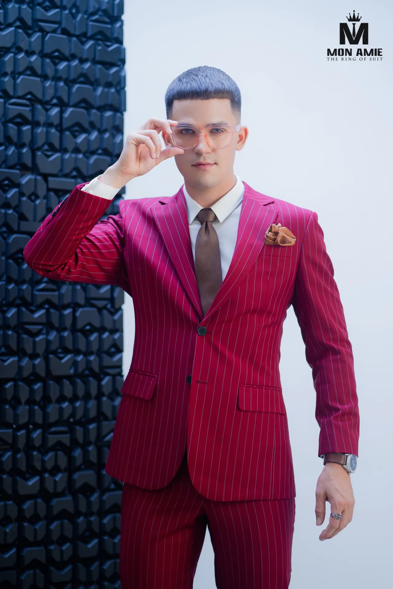 Blazer nhung đỏ hoạ tiết chìm, sơ mi đen bên tủ gỗ chạm khắc
