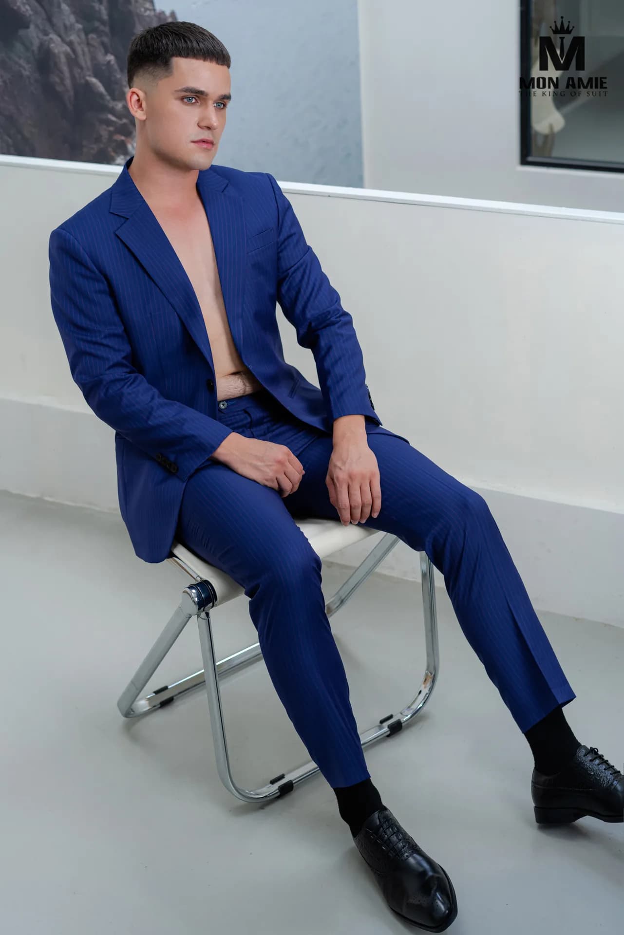 Suit ô xanh dương nhạt phối gilet xám, bình gốm men ngọc và đèn thả