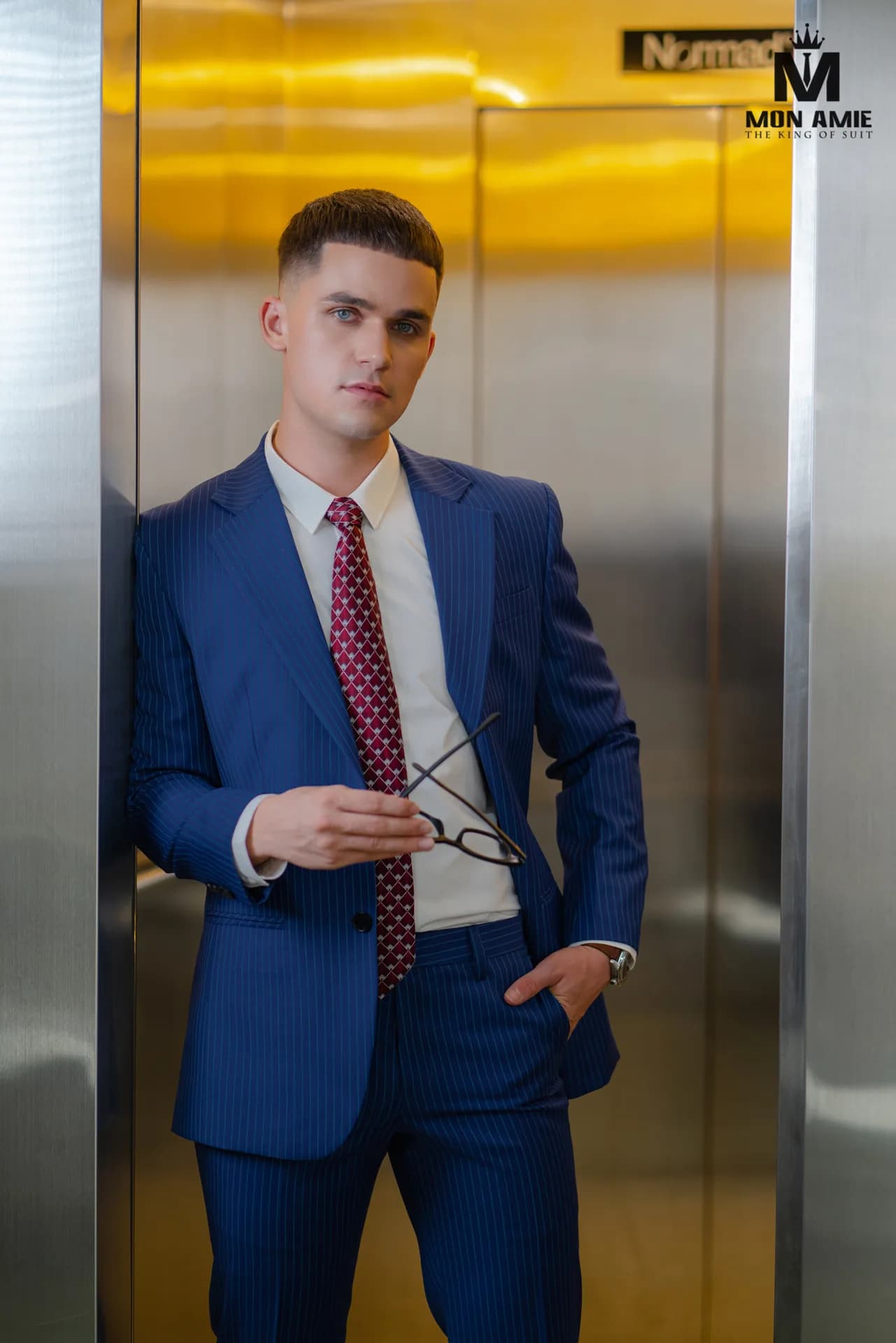 Suit kẻ ô xanh lá hai hàng khuy trước tấm gương khung gỗ chạm khắc