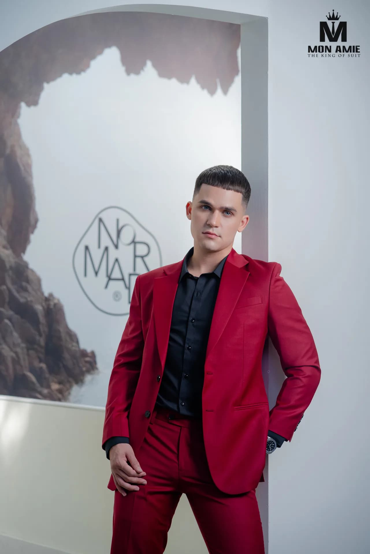 Suit xám kẻ ô phối áo lông thú, ngồi ghế nhung đỏ nhìn ra thành phố