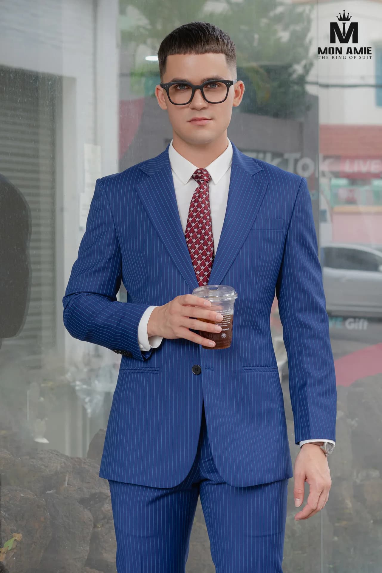Suit xanh navy ba mảnh, cà vạt hoạ tiết, ngồi ghế sofa hoạ tiết đen vàng
