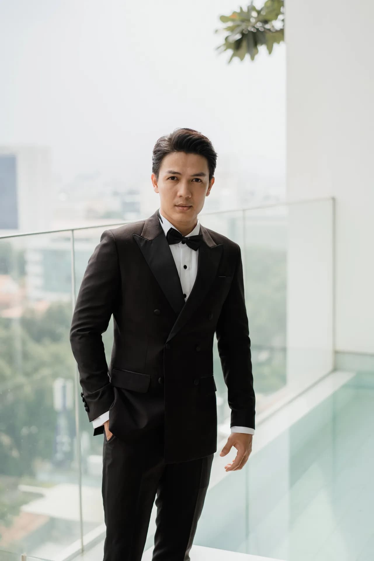 Tuxedo đen nơ đen, dáng đứng tự tin trên ban công kính