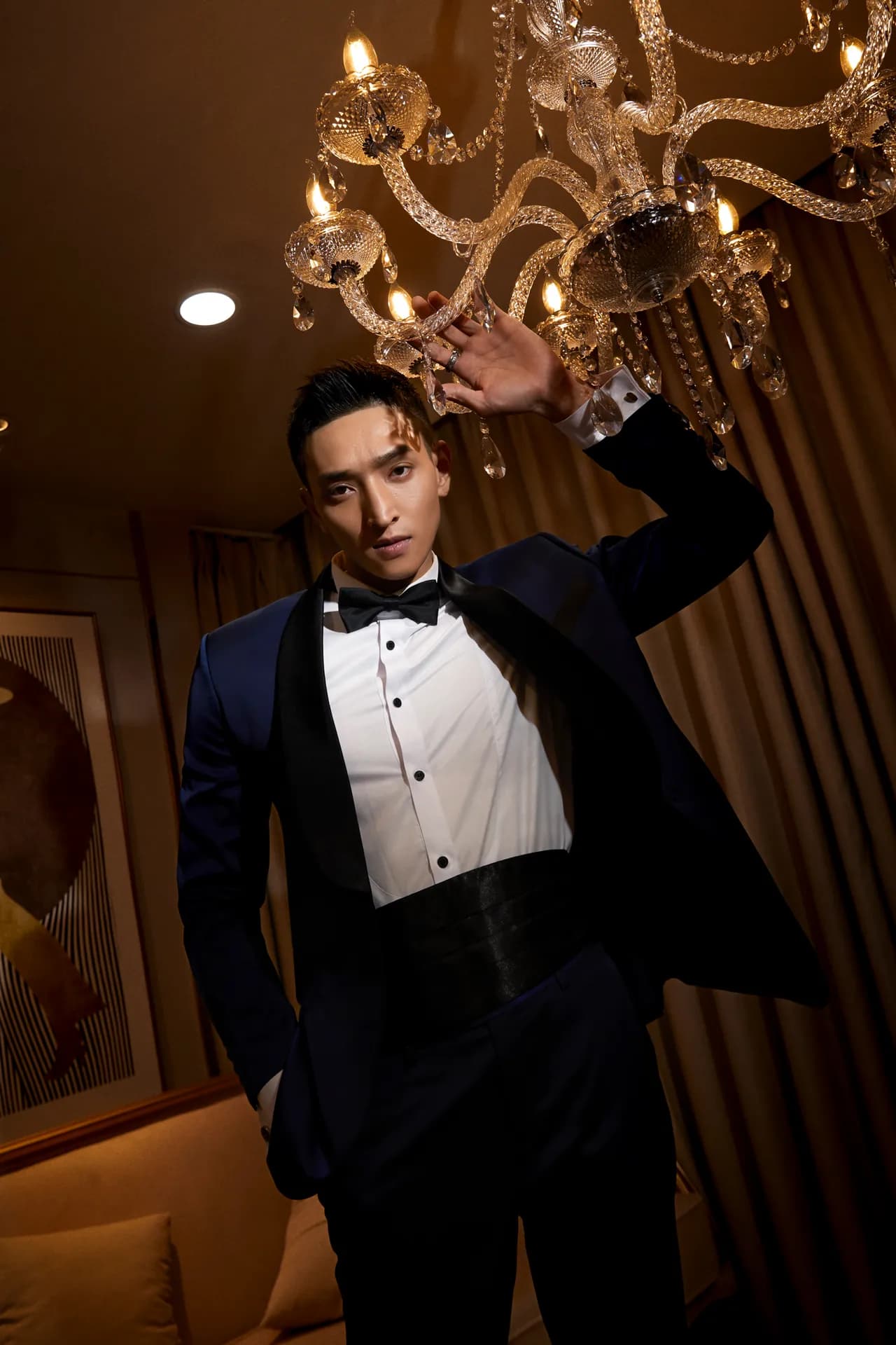 Tuxedo đen thắt nơ, thắt lưng bản rộng, tay chạm đèn chùm pha lê