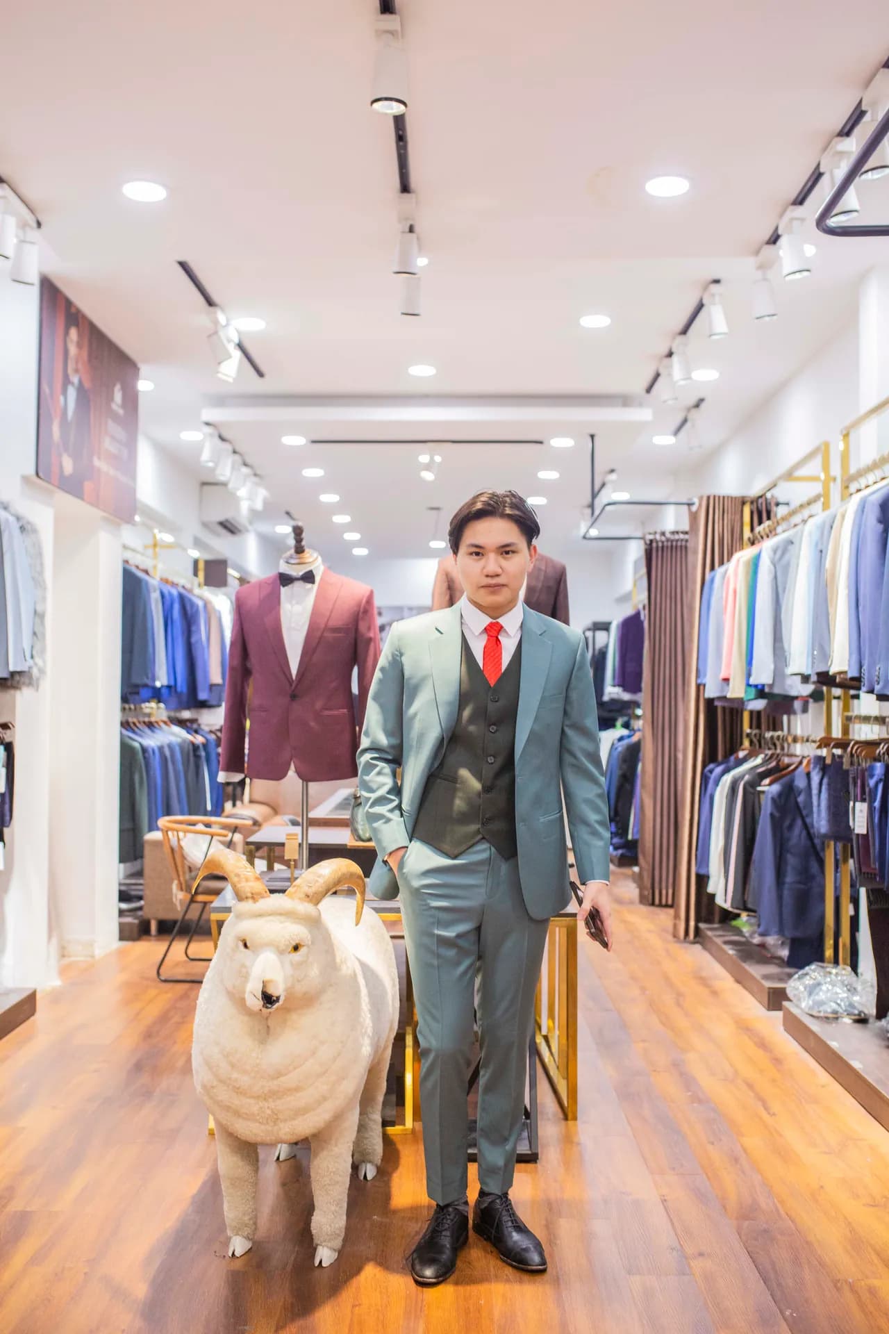 Khách thử suit ba mảnh xanh xô thơm cà vạt đỏ, bước đi giữa showroom