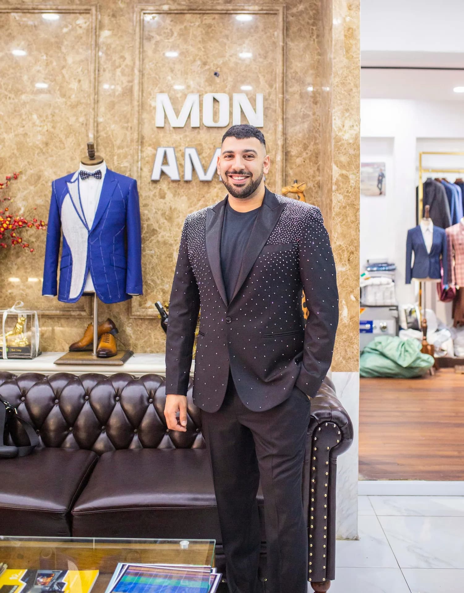Blazer đen đính hạt, sơ mi đen, khách cười tự tin trước vách đá MON AMIE