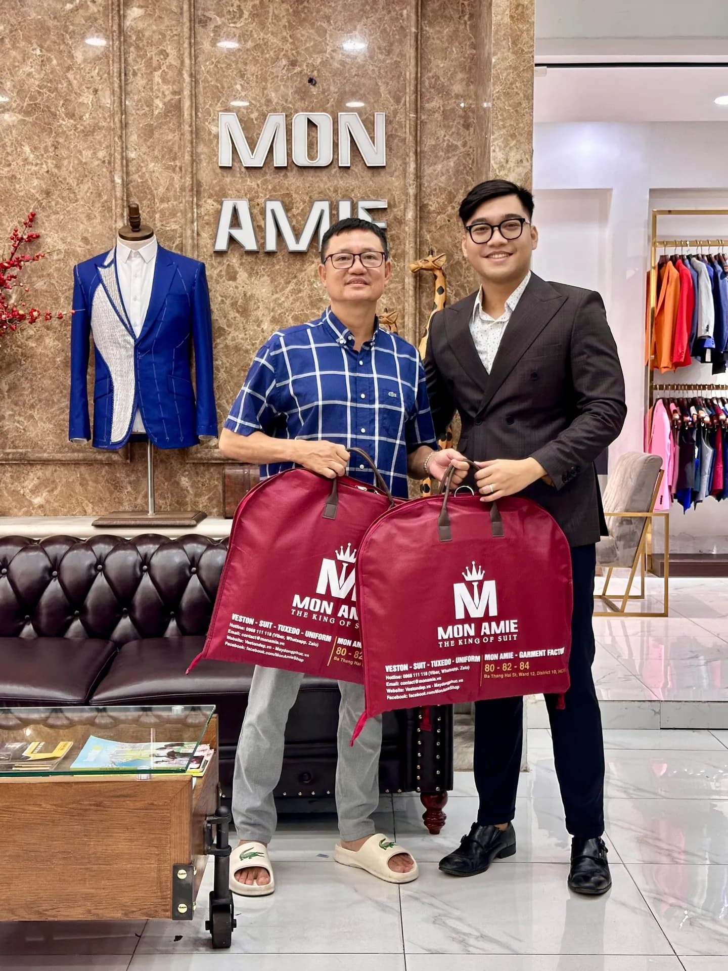 Khách nhận hai túi đựng vest Mon Amie từ nhân viên tư vấn tại showroom
