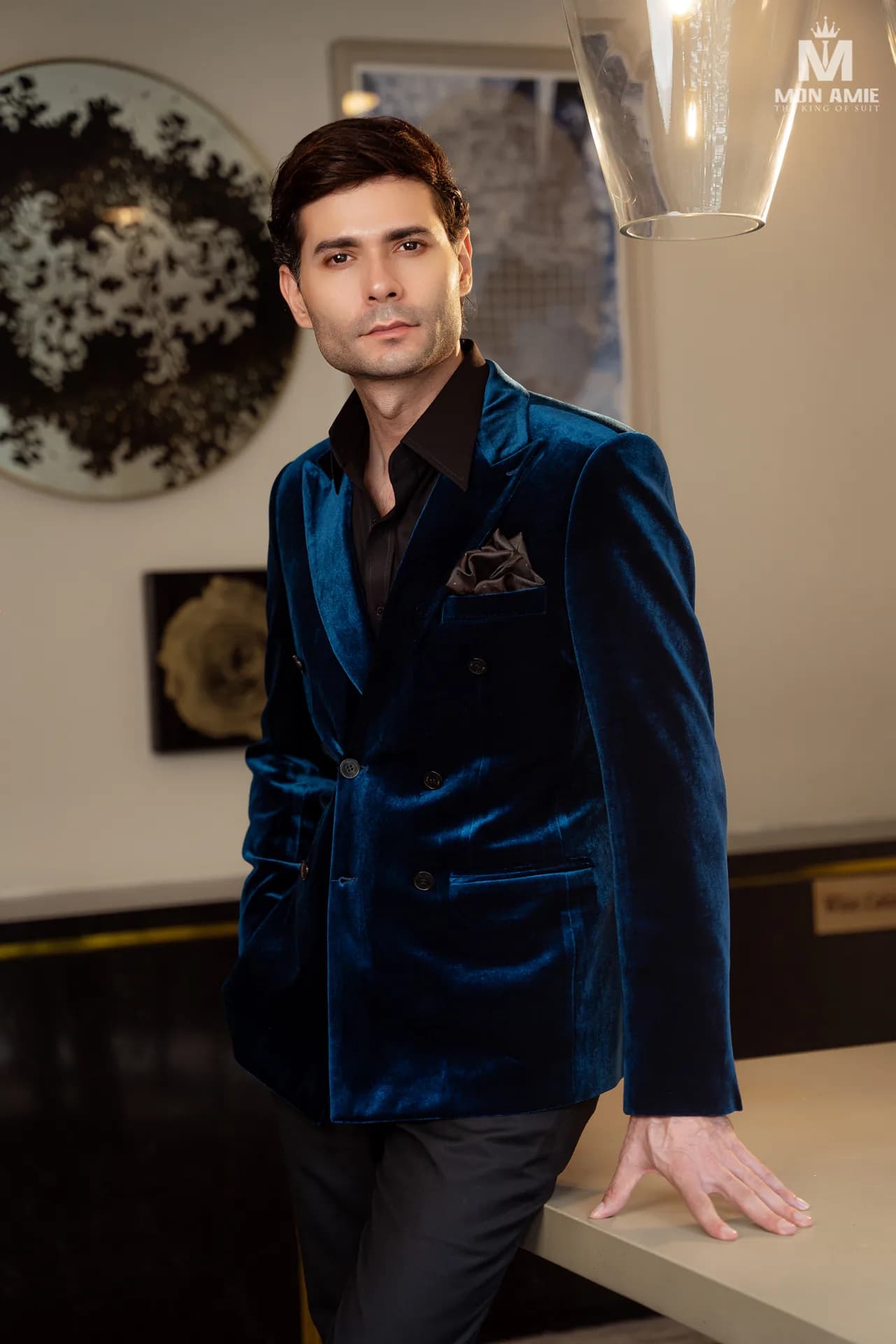 Blazer nhung xanh hai hàng khuy, ve nhọn, sơ mi đen, khăn cài túi satin.