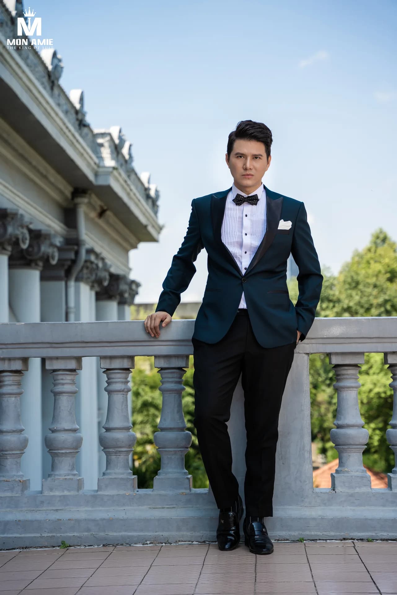 Toàn thân tuxedo xanh ngọc tựa lan can con tiện
