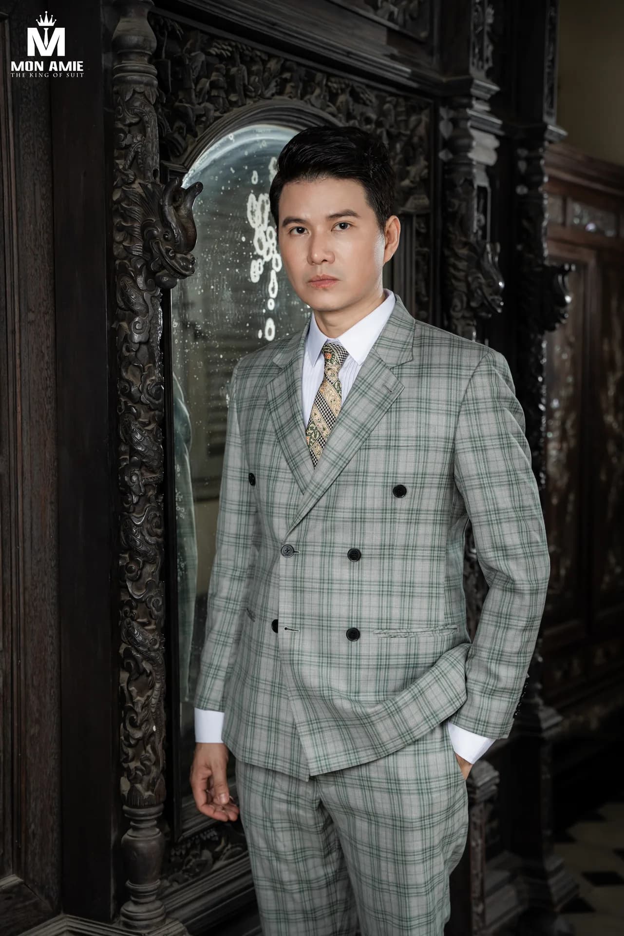 Chi tiết suit caro xanh lá cùng cà vạt hoạ tiết, nền gỗ chạm