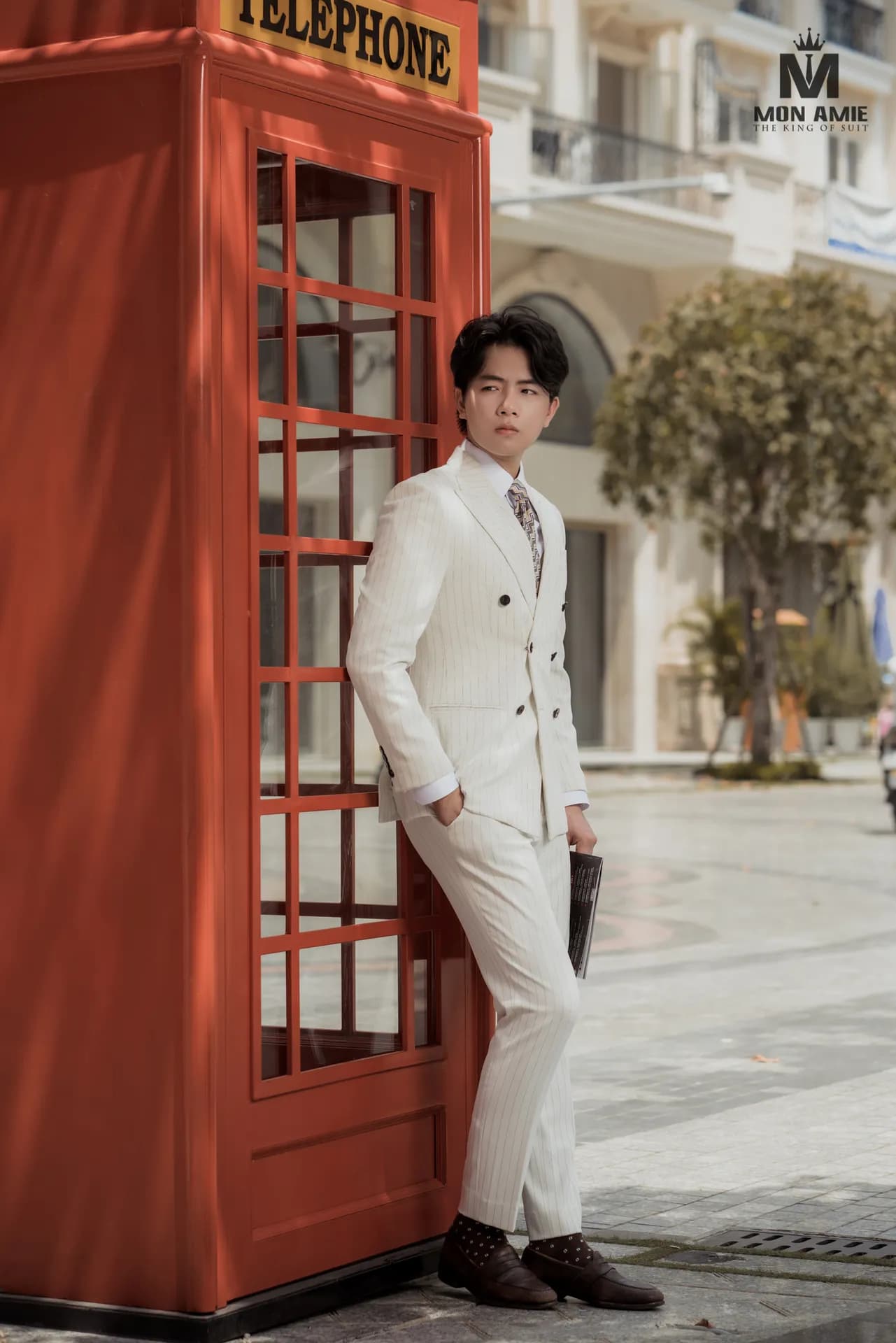 Suit trắng kem hai hàng khuy, tựa buồng điện thoại đỏ