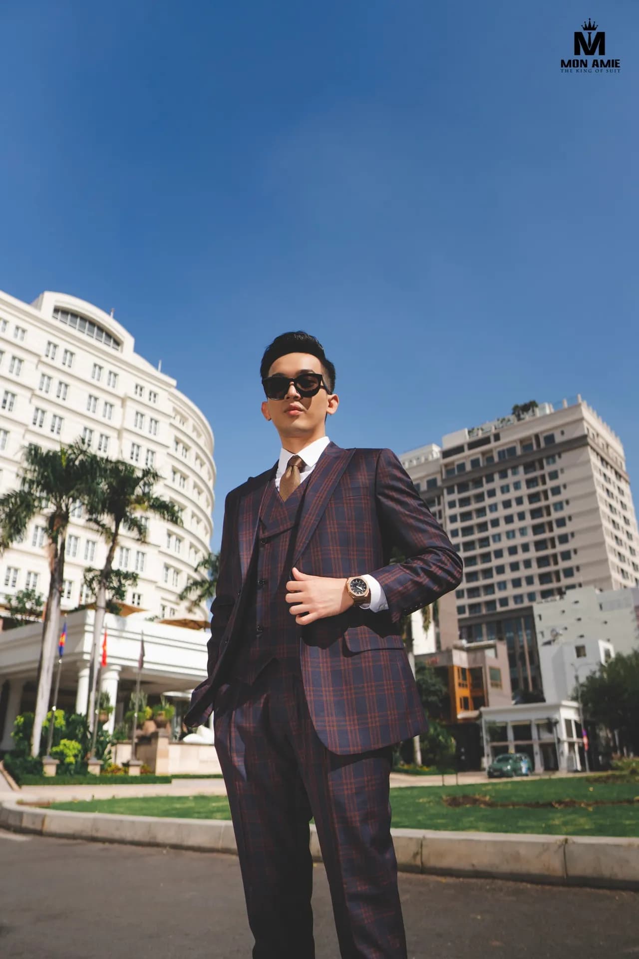 Suit ba mảnh caro tím, kính râm, đứng trên phố dưới trời xanh