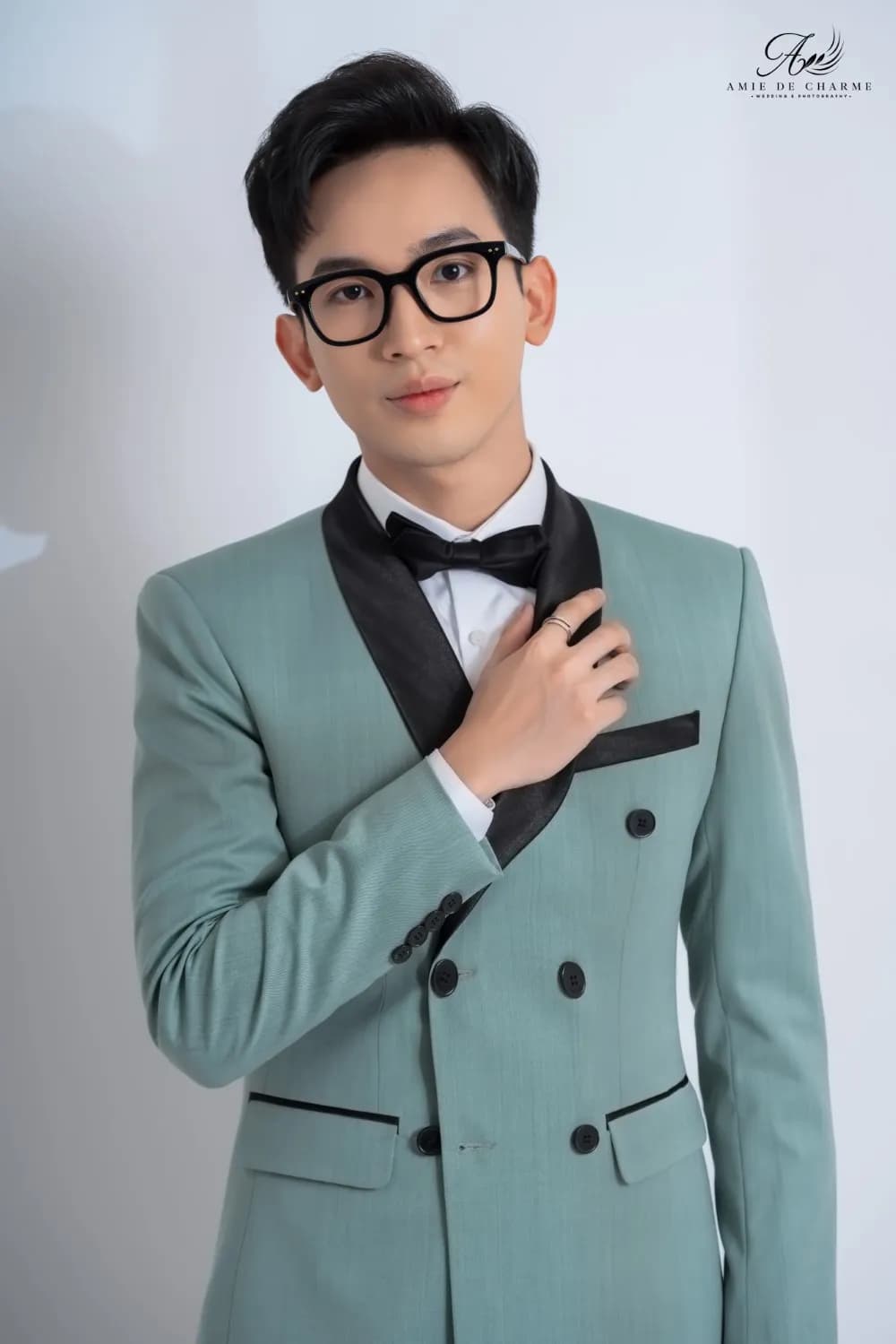 Cận cảnh blazer xanh bạc hà cổ ve satin đen, nơ đen, tay chỉnh ve áo