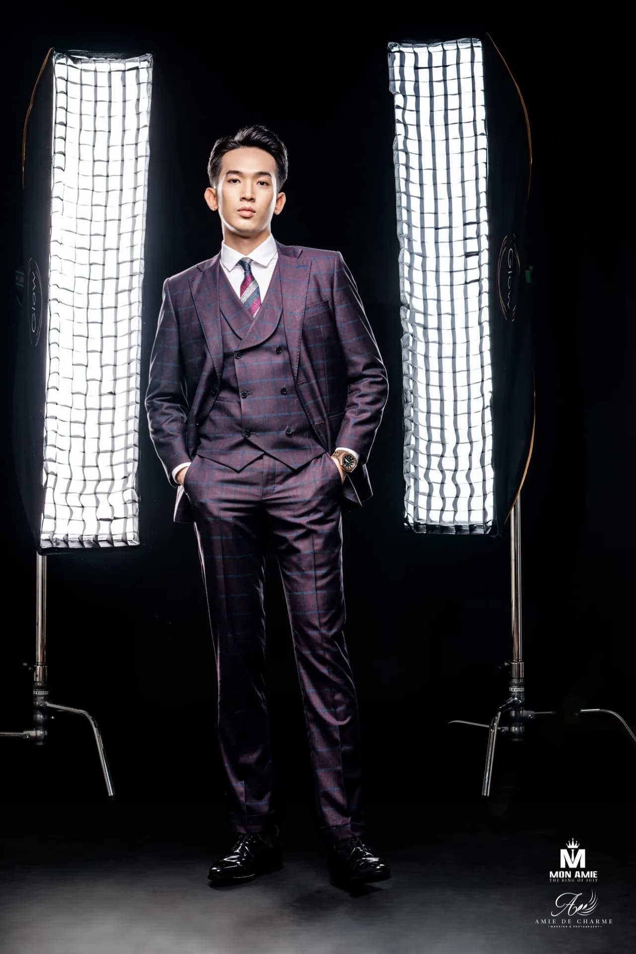 Suit ba mảnh tím than kẻ ô, đứng tay đút túi giữa hai đèn softbox nền đen