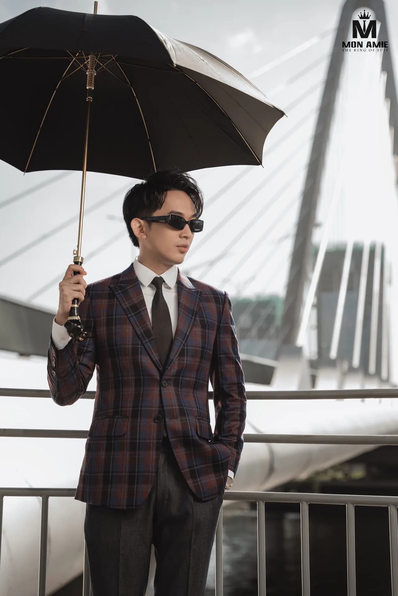 Blazer caro tím đô, kính râm, che ô đen, nền cây cầu trắng