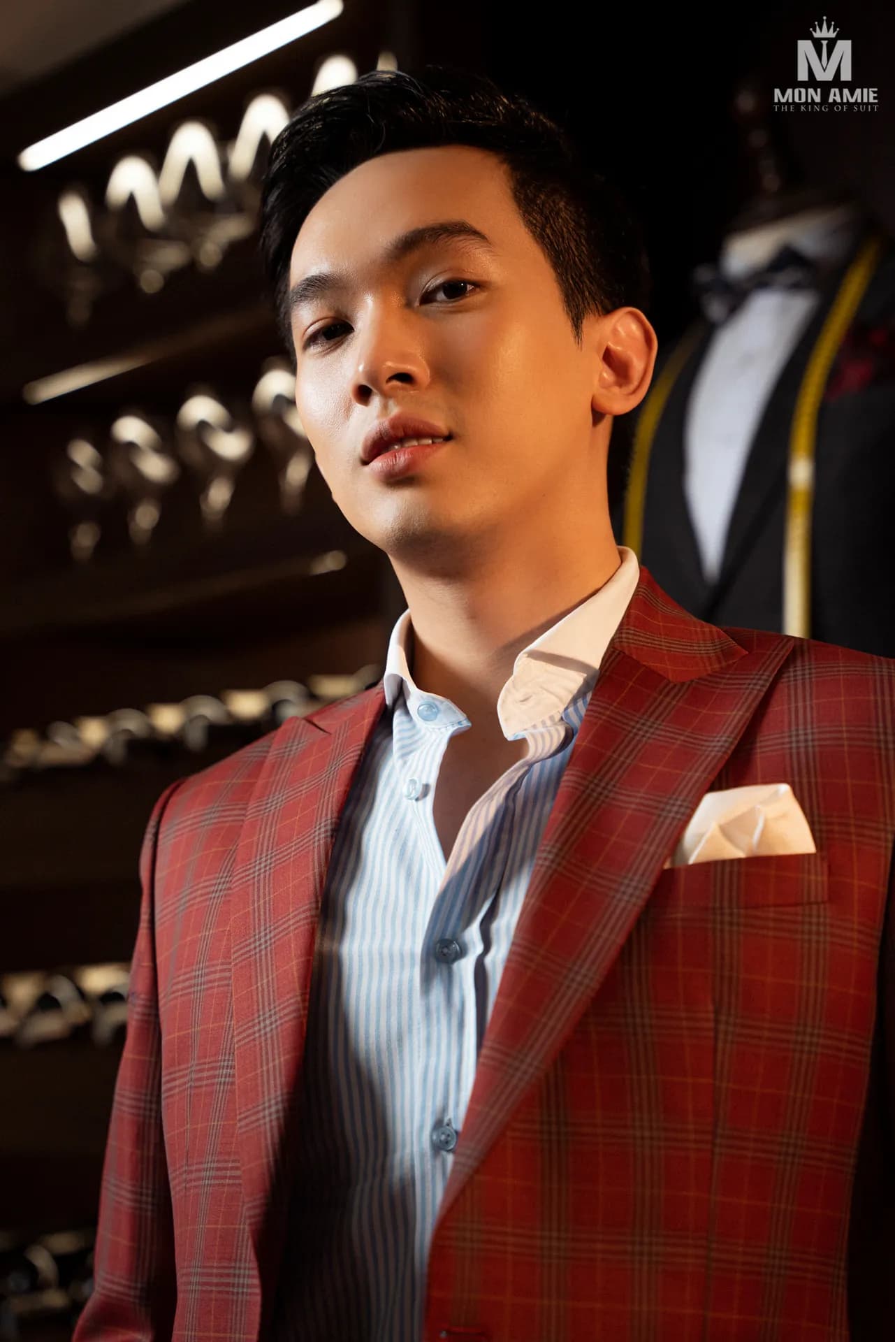 Blazer đỏ kẻ ô, sơ mi sọc xanh, khăn cài túi trắng, chân dung cận cảnh