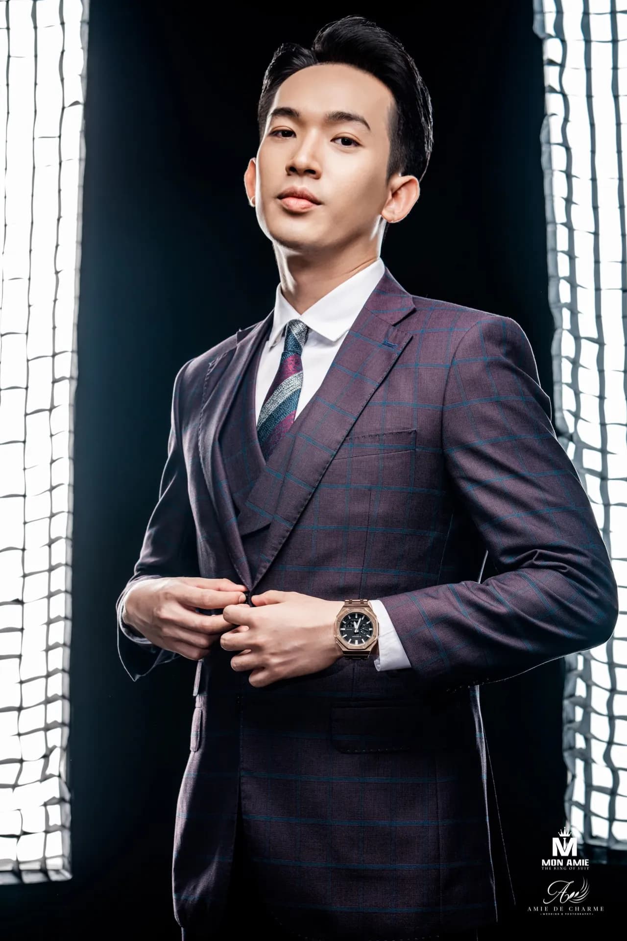 Suit ba mảnh tím than kẻ ô, tay cài khuy, ánh nhìn thẳng, nền đen đèn softbox