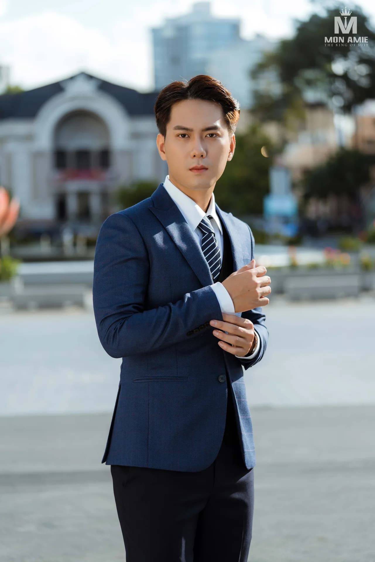 Chỉnh khuy măng sét, suit navy kẻ chìm và cà vạt sọc
