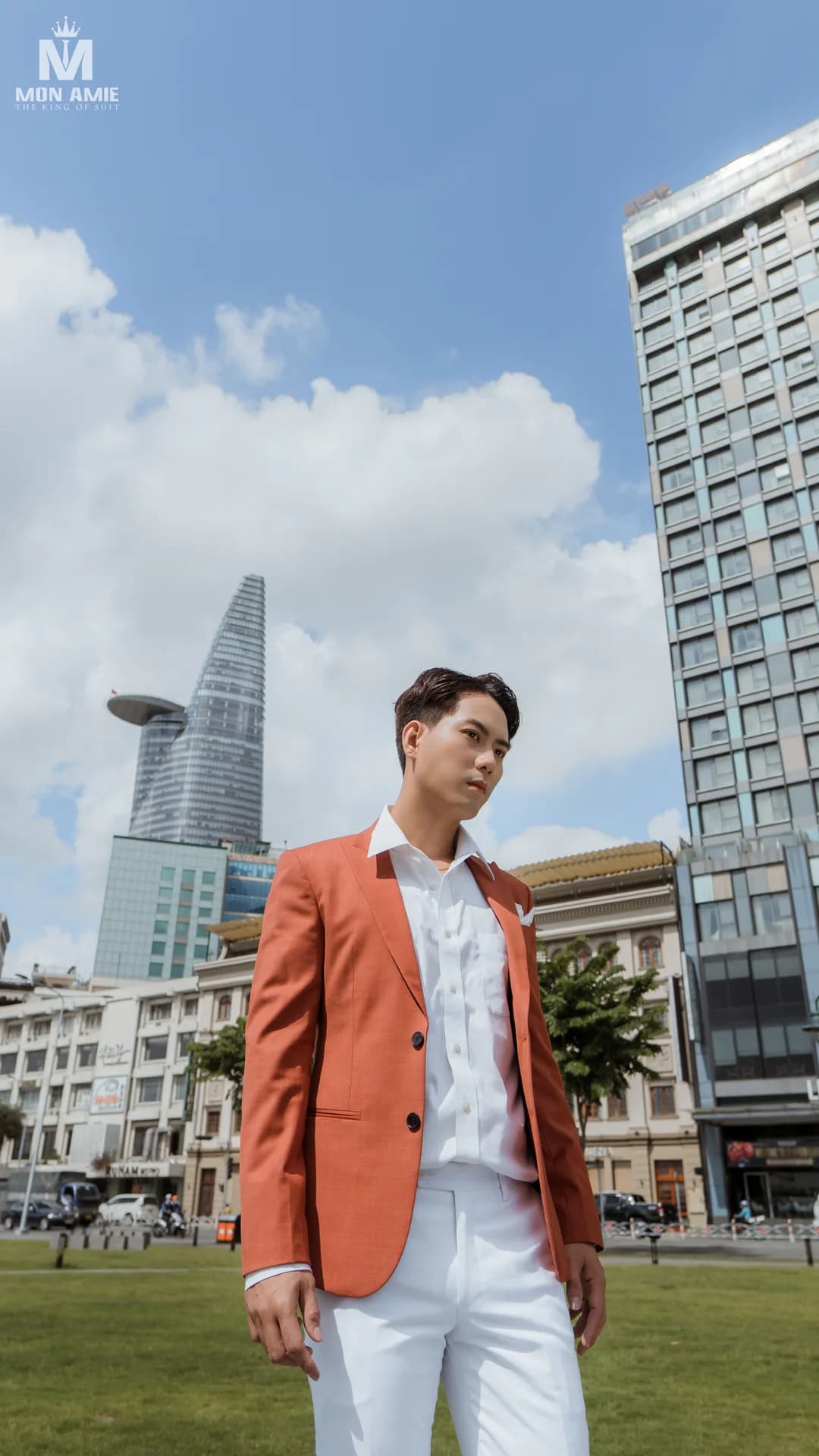 Blazer cam đất, quần trắng giữa quảng trường với toà nhà cao tầng