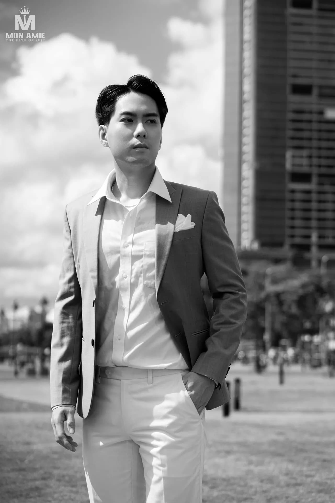Ảnh đen trắng vest xám, sơ mi mở cổ, giữa quảng trường thành phố