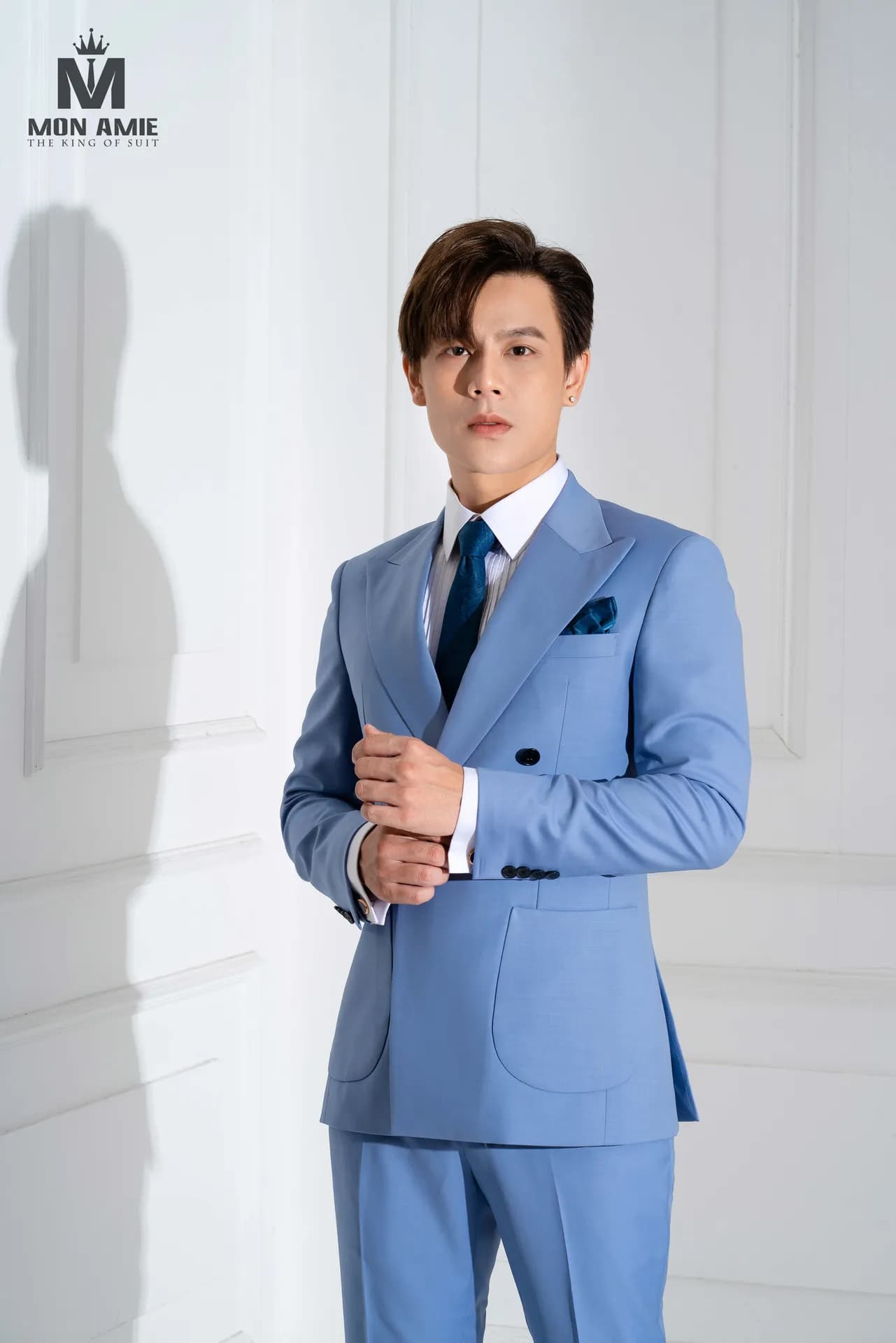Suit xanh da trời hai hàng khuy, khăn cài túi xanh, chỉnh măng sét