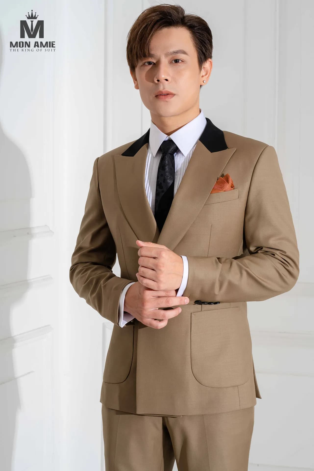 Suit hai hàng khuy nâu cổ nhung đen, cà vạt đen, khăn cài túi cam