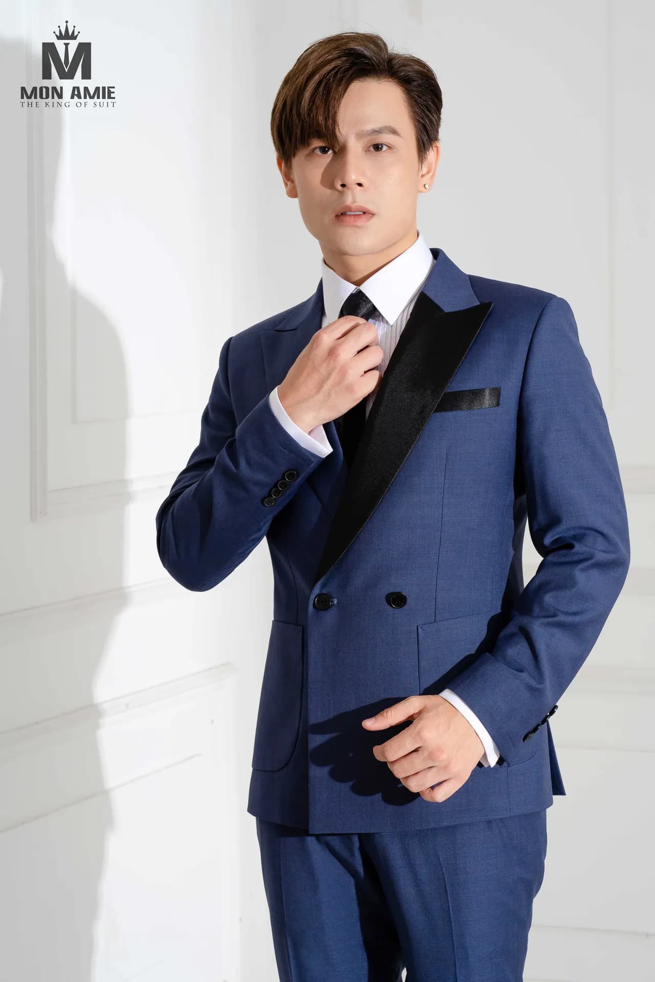 Suit xanh navy ve nhung đen, chỉnh cà vạt, cận cảnh