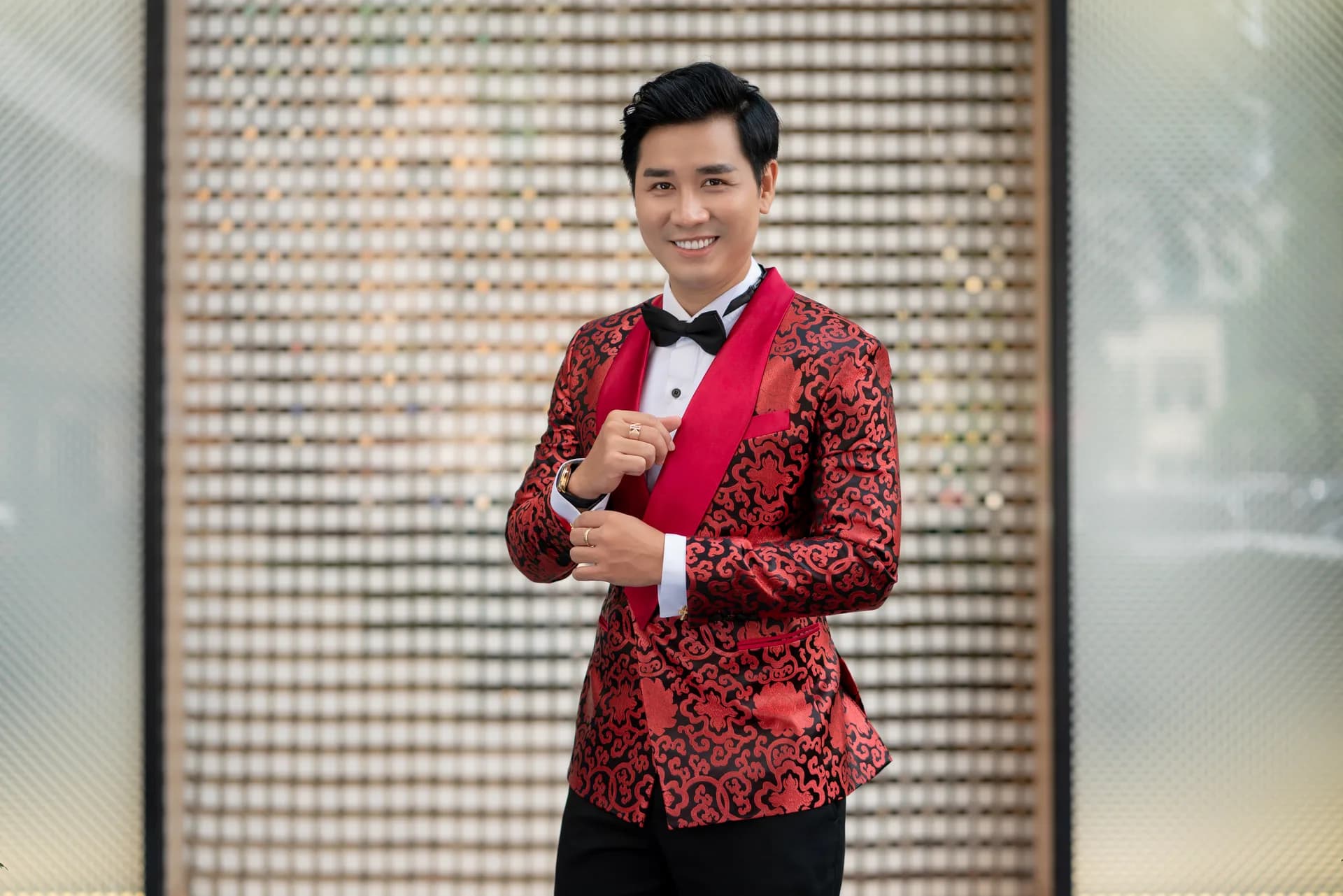 Tuxedo jacquard đỏ, chỉnh măng sét, nền lưới gỗ ánh vàng